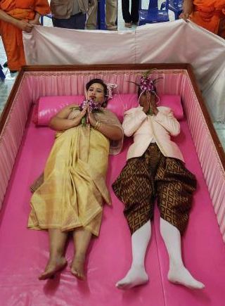 泰国新婚夫妇情人节办婚礼 躺粉色棺材求好运