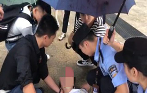 女子鬧市暈倒 輔警跪地撐傘